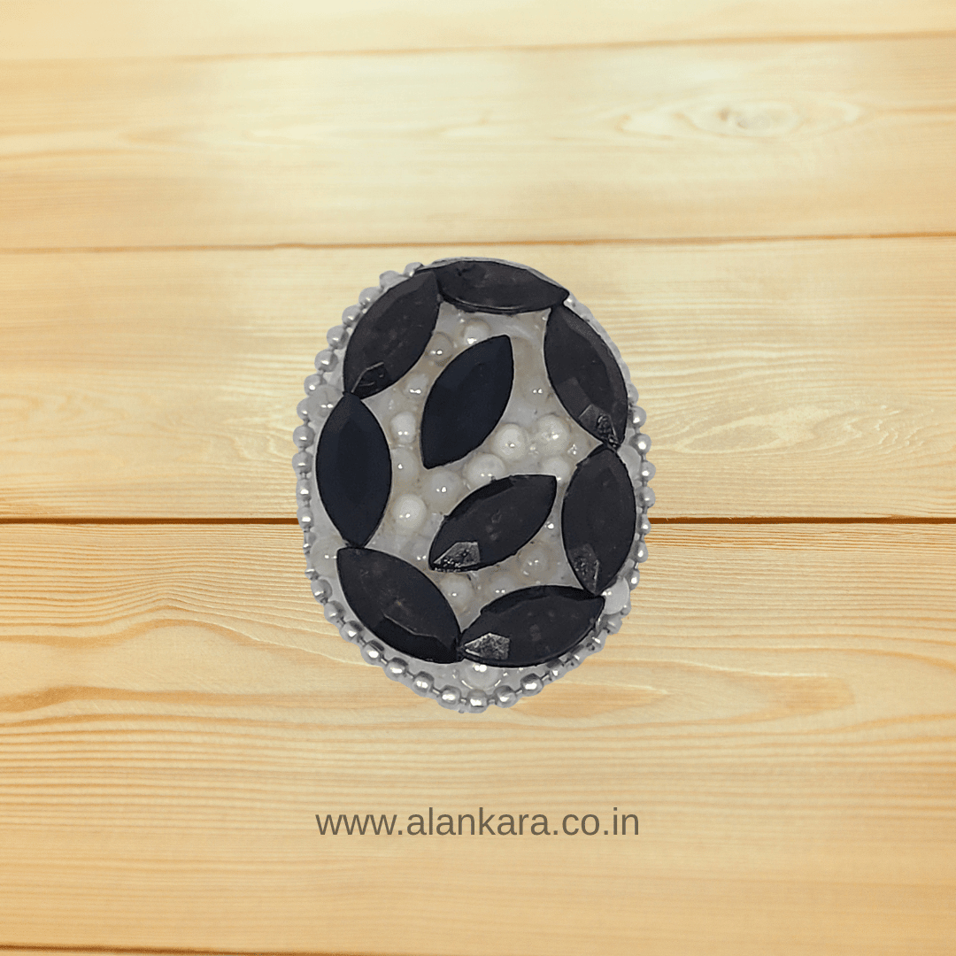 Black Crystal Pearl Saree Pin showcasing bold black crystals and elegant pearls on a wooden background.