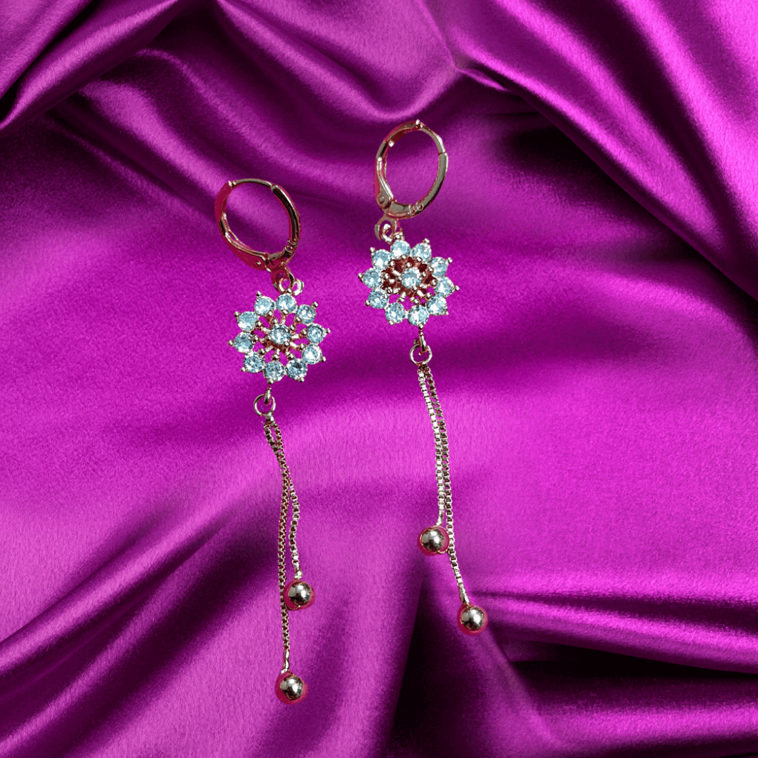 Golden white floral dangler earring on a purple satin background, perfect for Indian and western outfits.