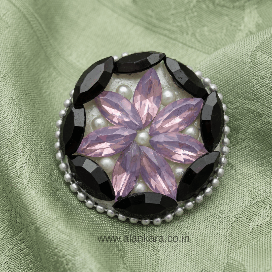 Black & Lavender Crystal Pearl Saree Pin featuring a floral design with pearls and crystals on a textured green background.