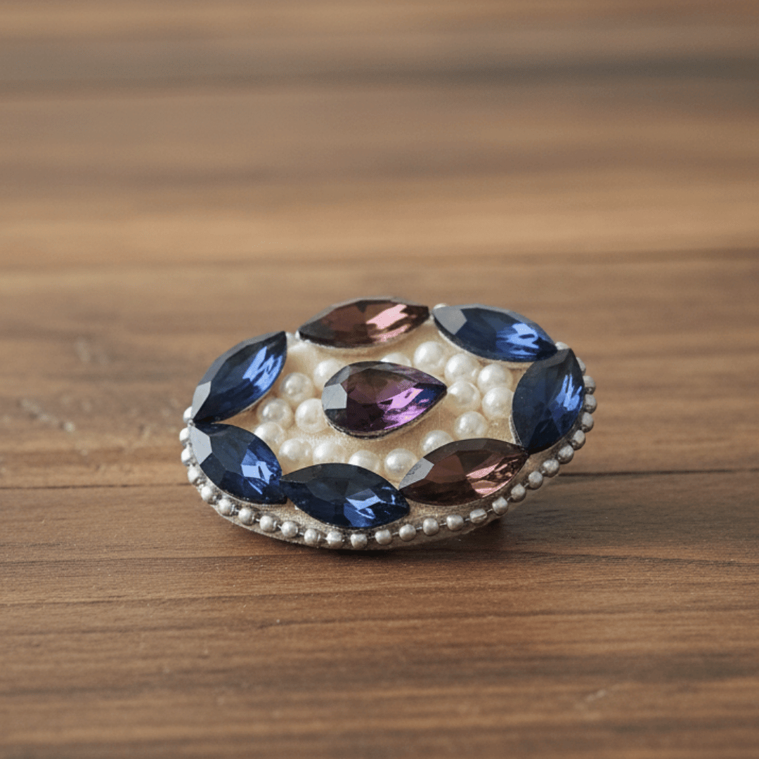 Wine Blue Crystal Pearl Saree Pin featuring sparkling crystals and pearls on a wooden background.