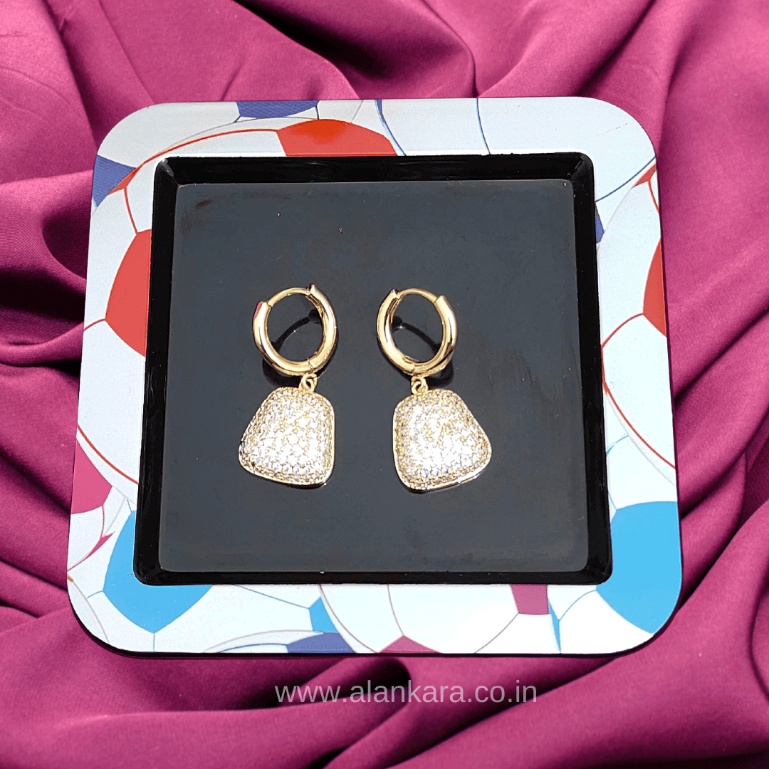 White Party Purse Stud earrings displayed on a colorful tray against a purple background.