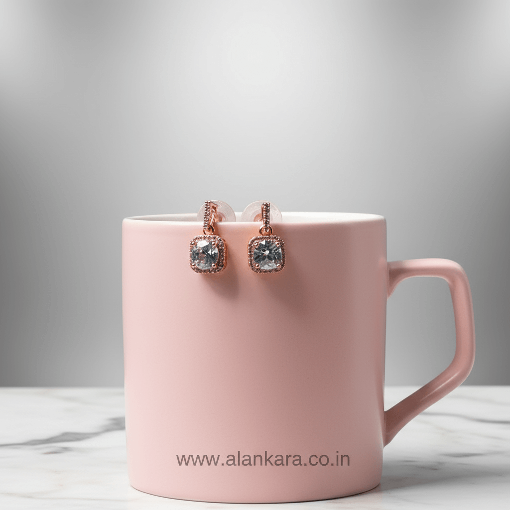 Pink mug with earrings on a light gray background
