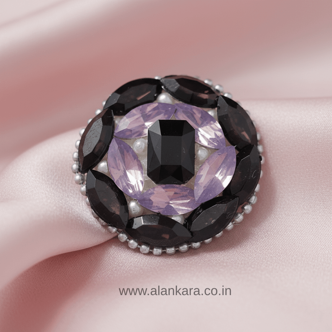 Black Orchid Crystal Pearl Saree Pin featuring black, lavender crystals, and pearls on a soft fabric background.