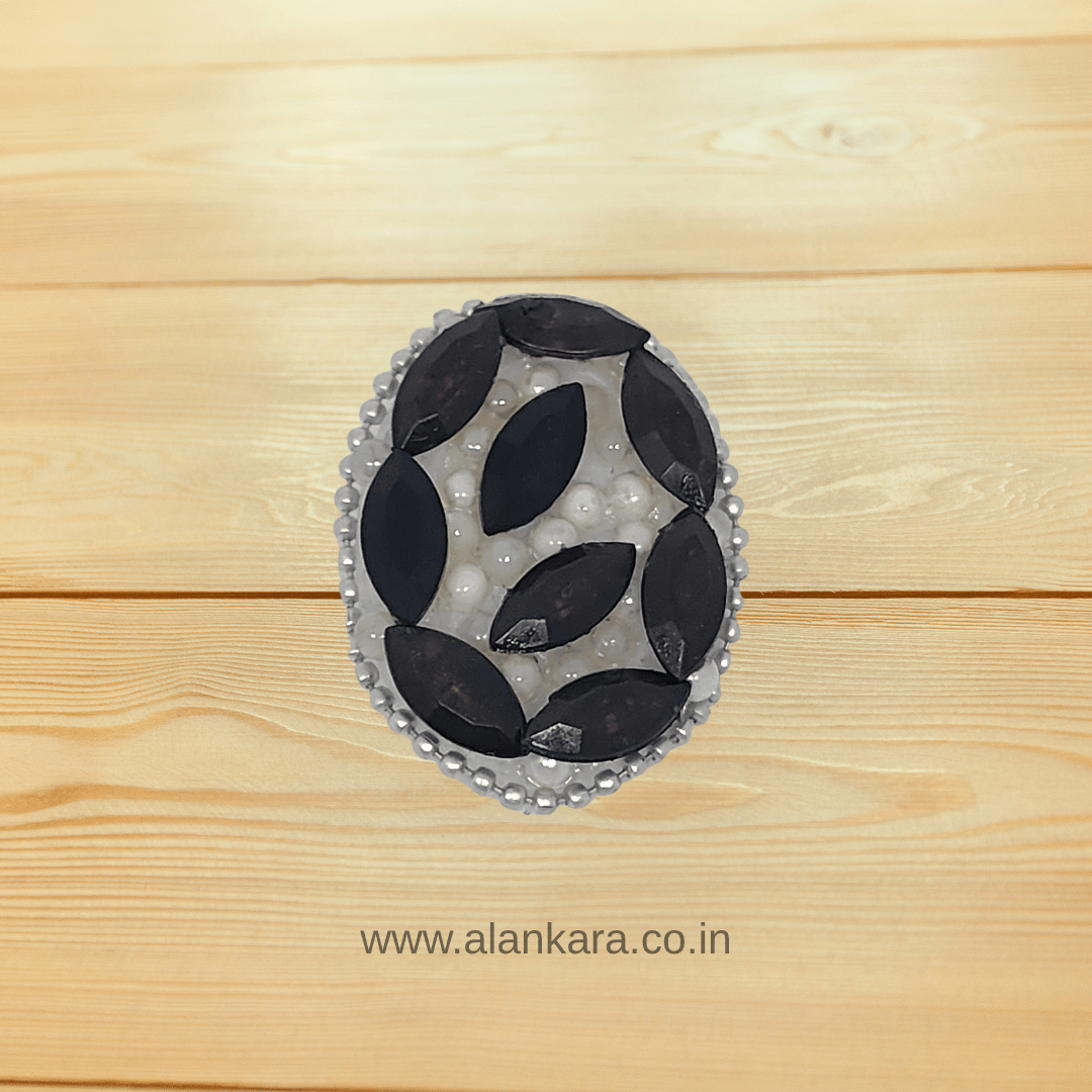 Black Crystal Pearl Saree Pin showcasing bold black crystals and elegant pearls on a wooden background.