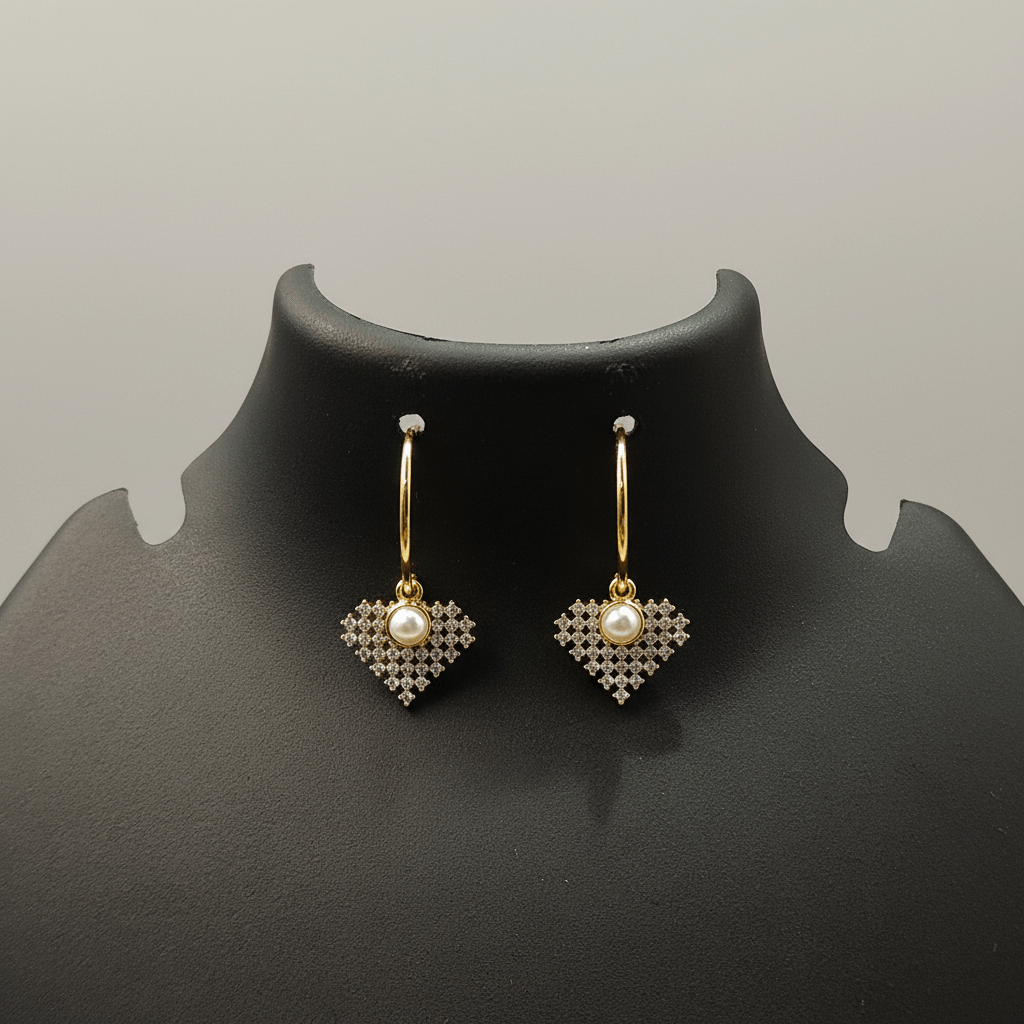 Heart-shaped earrings with pearls on a black mannequin bust against a gray background
