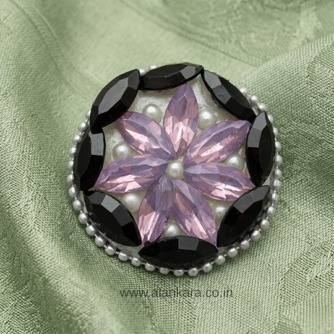 Black & Lavender Crystal Pearl Saree Pin featuring a floral design with pearls and crystals on a textured green background.