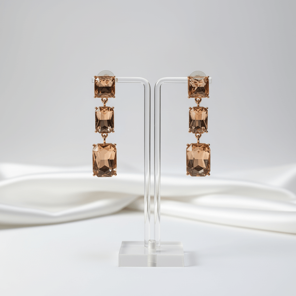 Peach colour earrings on a white stand with w fabricitefabric backdrop