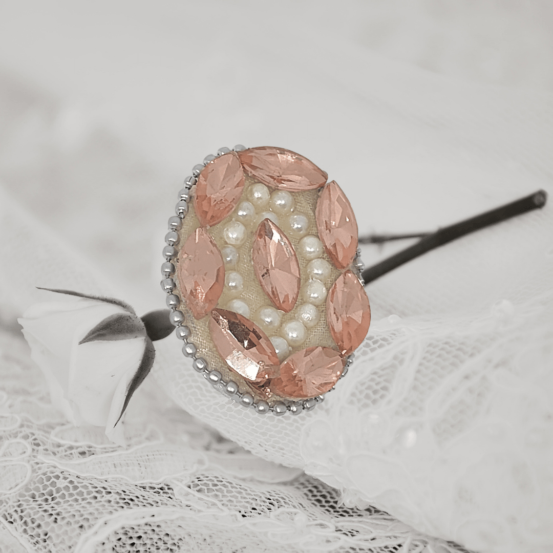 Peach Crystal Pearl Saree Pin featuring sparkling crystals and pearls on a delicate lace background.