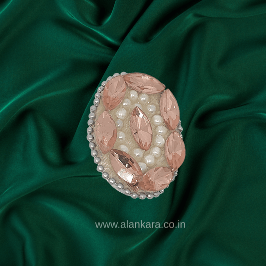Peach Crystal Pearl Saree Pin featuring sparkling crystals and pearls on a green silk background.