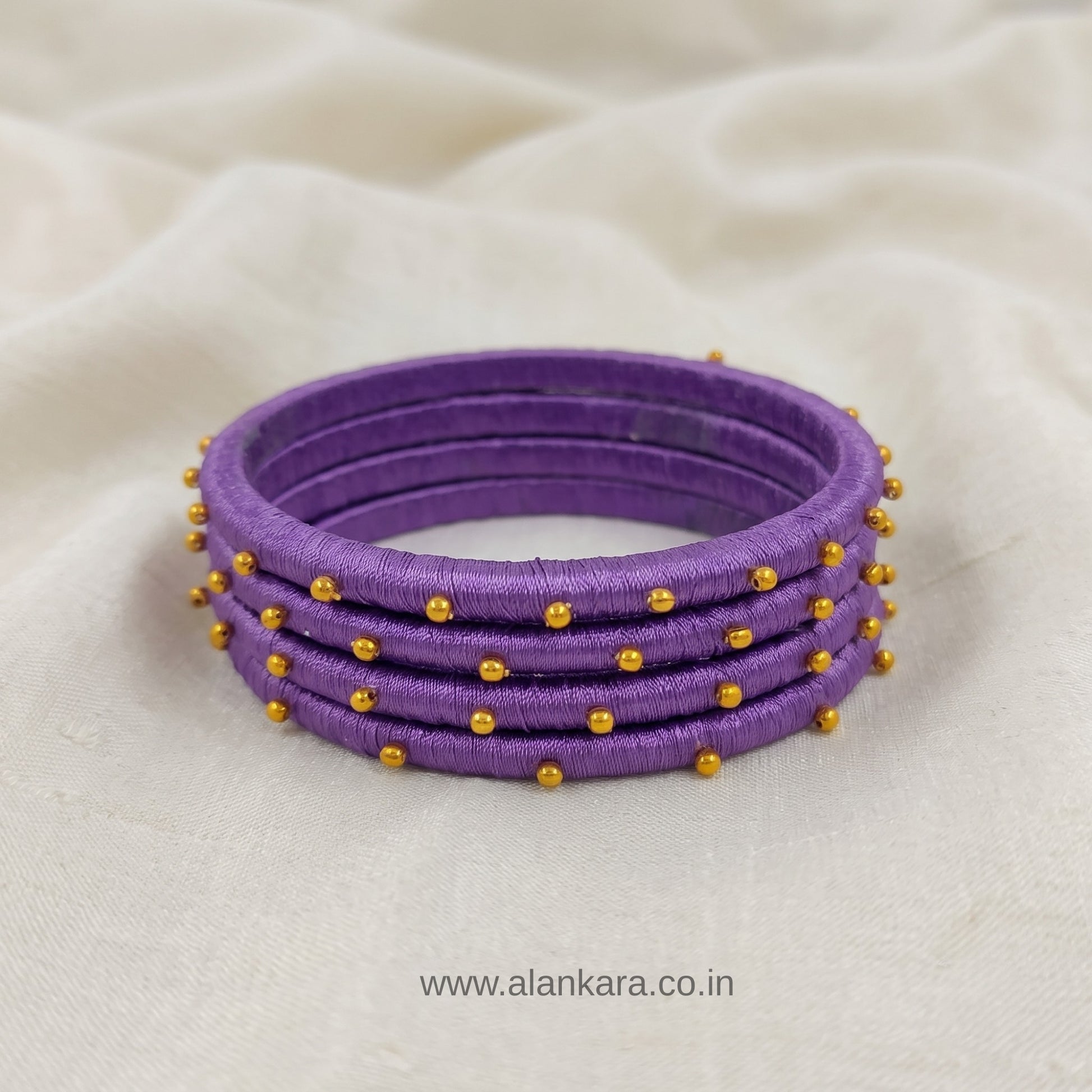 Royal Purple Golden Silk Thread Bangles featuring vibrant purple silk and golden beads, perfect for festive wear.
