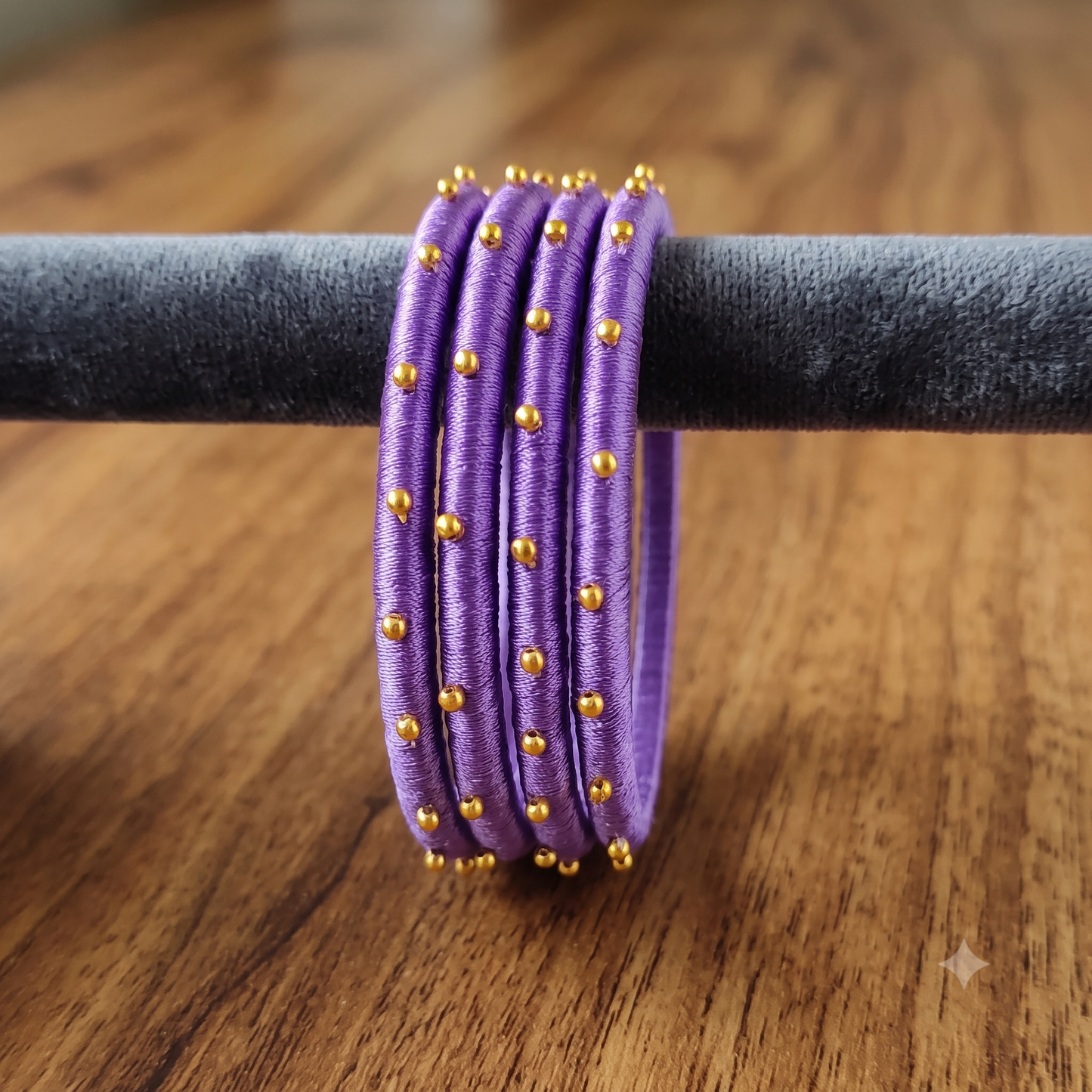 Royal Purple Golden Silk Thread Bangles featuring rich purple silk and golden beads on a display.