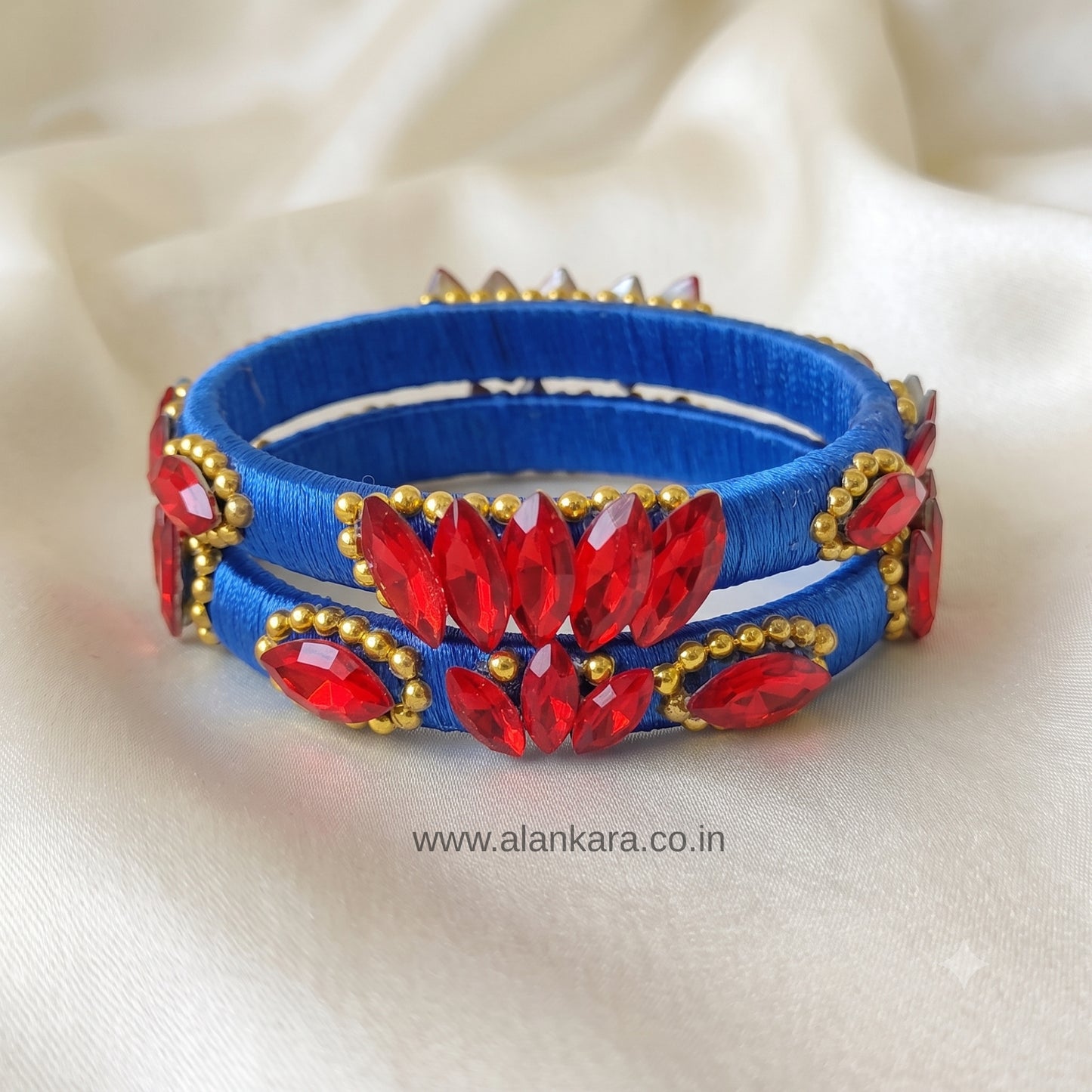 Royal Blue Red Crystal Silk Thread Kada Bangles adorned with vibrant red crystals and golden beads.