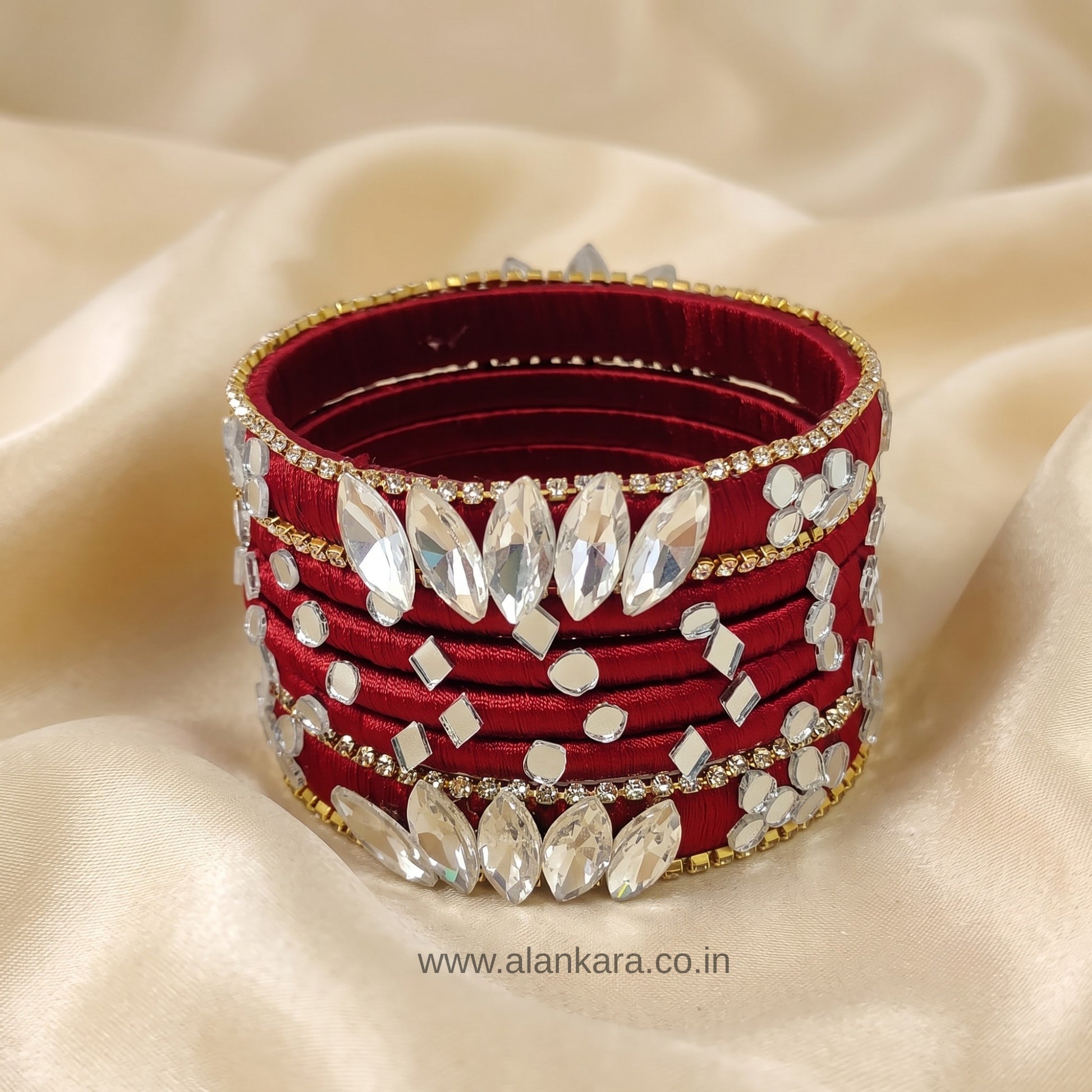 White Crystal Wine Silk Thread Bangles with sparkling crystals and gold detailing on a satin background.