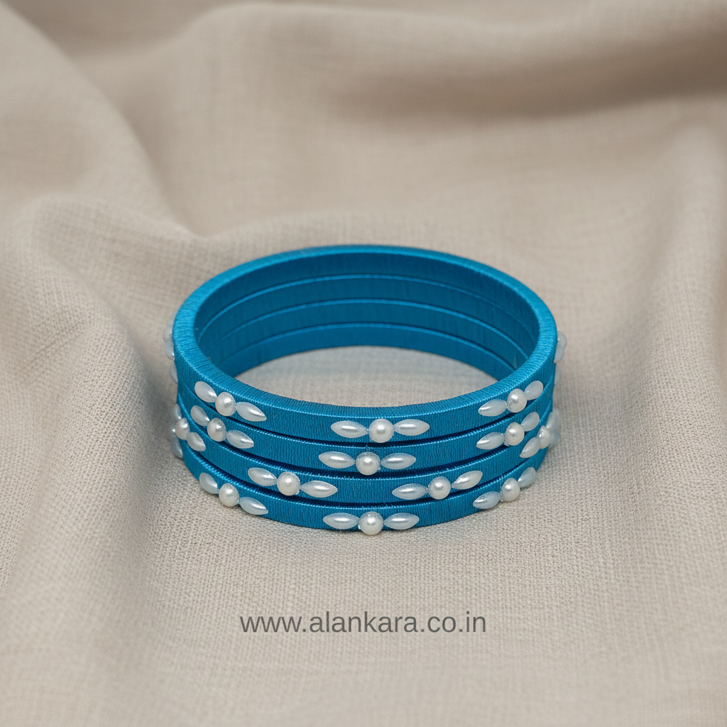 Blue Pearl Silk Thread Bangles showcasing vibrant sky-blue silk and white pearl detailing on a soft beige background.