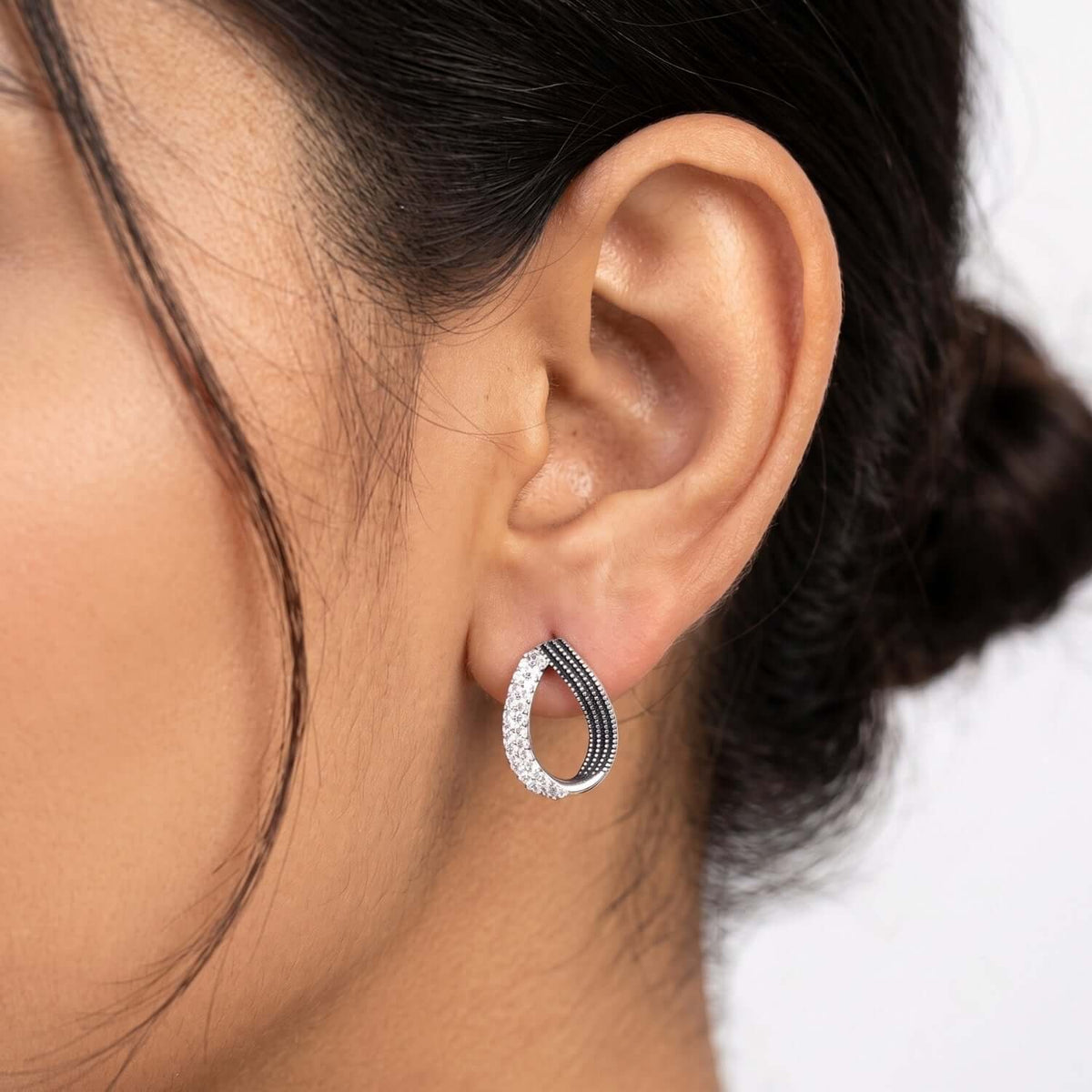 Close-up of a model wearing a stylish Black White Eye Stud earring, showcasing the intricate design and color contrast.