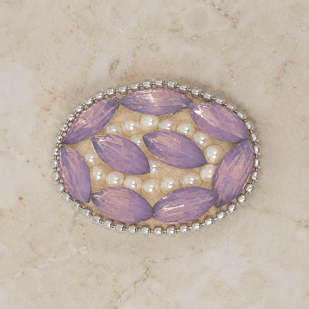 Lavender Crystal Pearl Saree Pin with sparkling crystals and delicate pearls on a marble background.