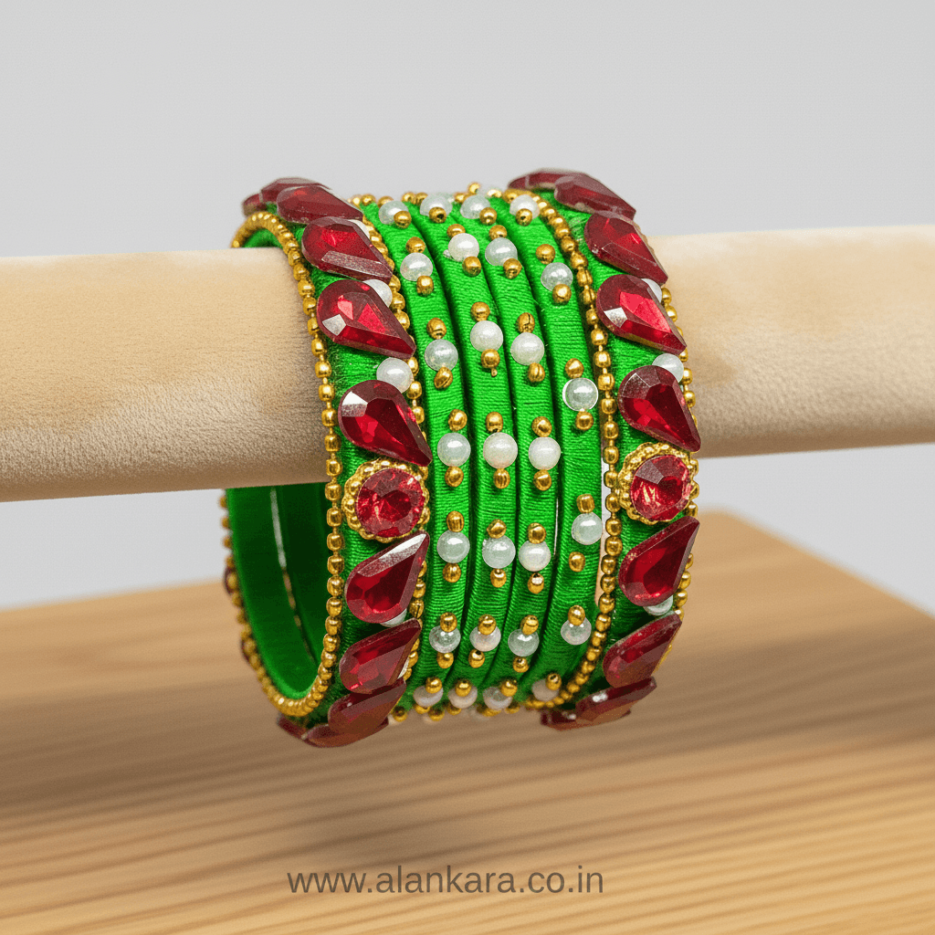 Green & Red Crystal Silk Thread Bangles featuring vibrant silk, red crystals, pearls, and golden beads on a display.
