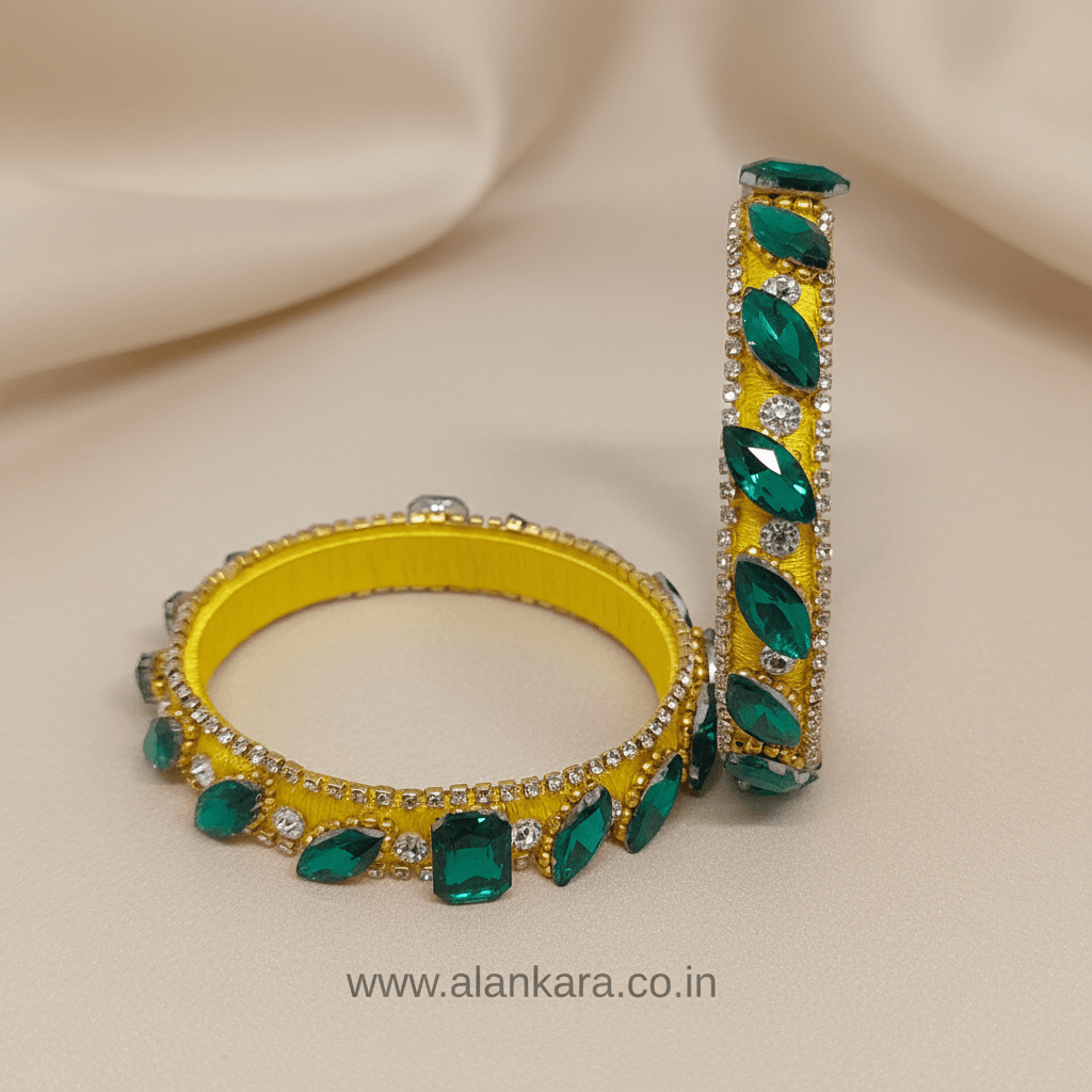 Yellow & Green Noori Silk Thread Kada Bangles with emerald stones and crystals on a soft background.