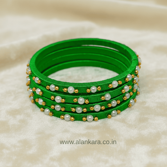 Green Pearl Silk Thread Bangles showcasing vibrant green silk threads adorned with delicate white pearls and golden beads.