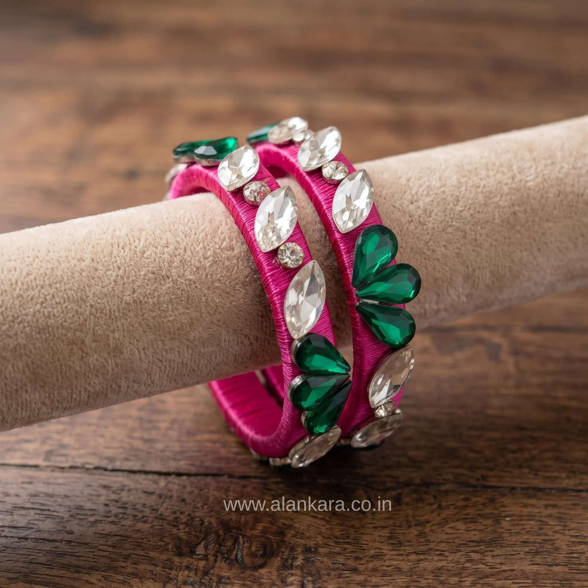 Rani pink floral crystal silk thread bangles featuring green and white crystals arranged in a floral design.