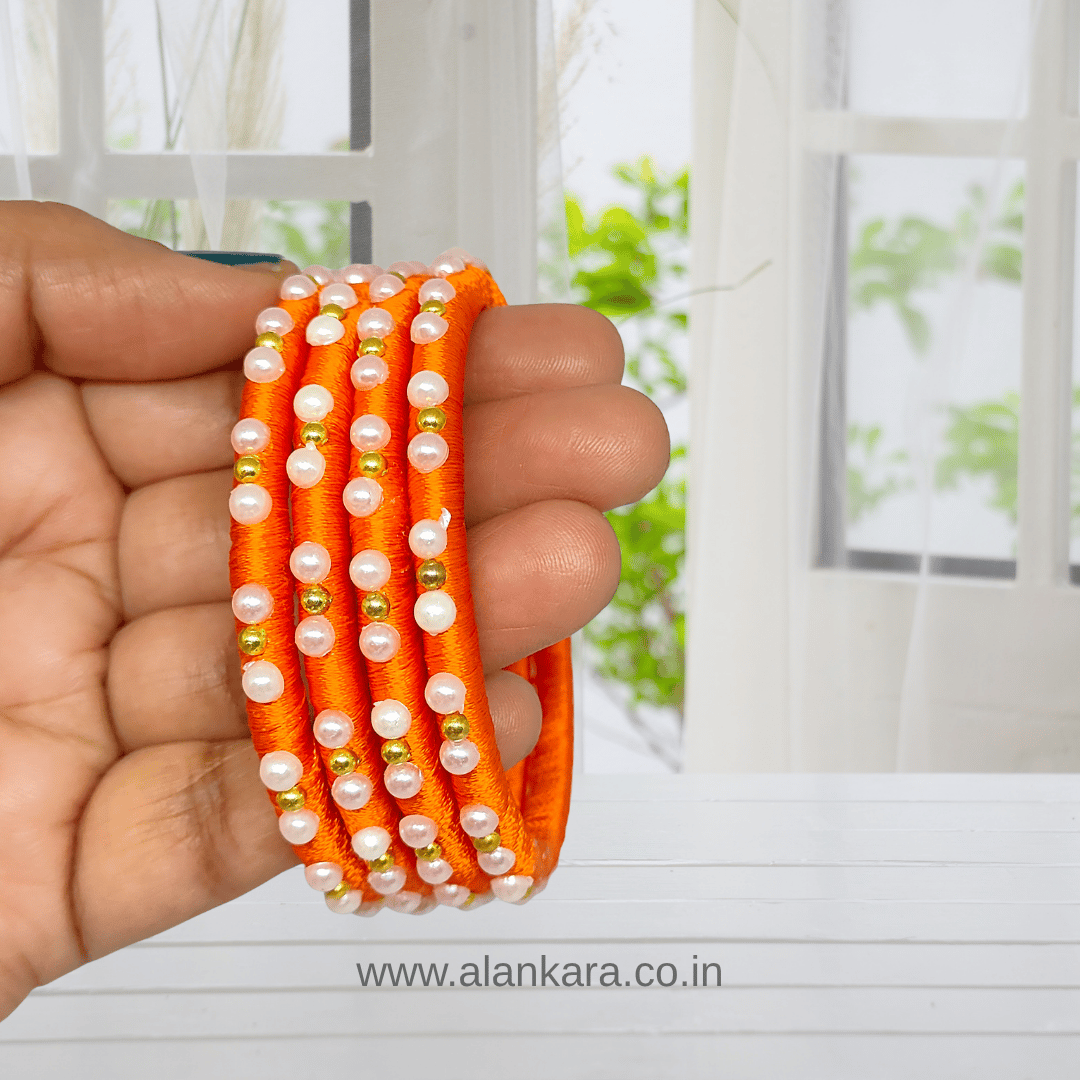Orange Pearl Silk Thread Bangles with vibrant orange silk and white pearls, perfect for festive occasions.