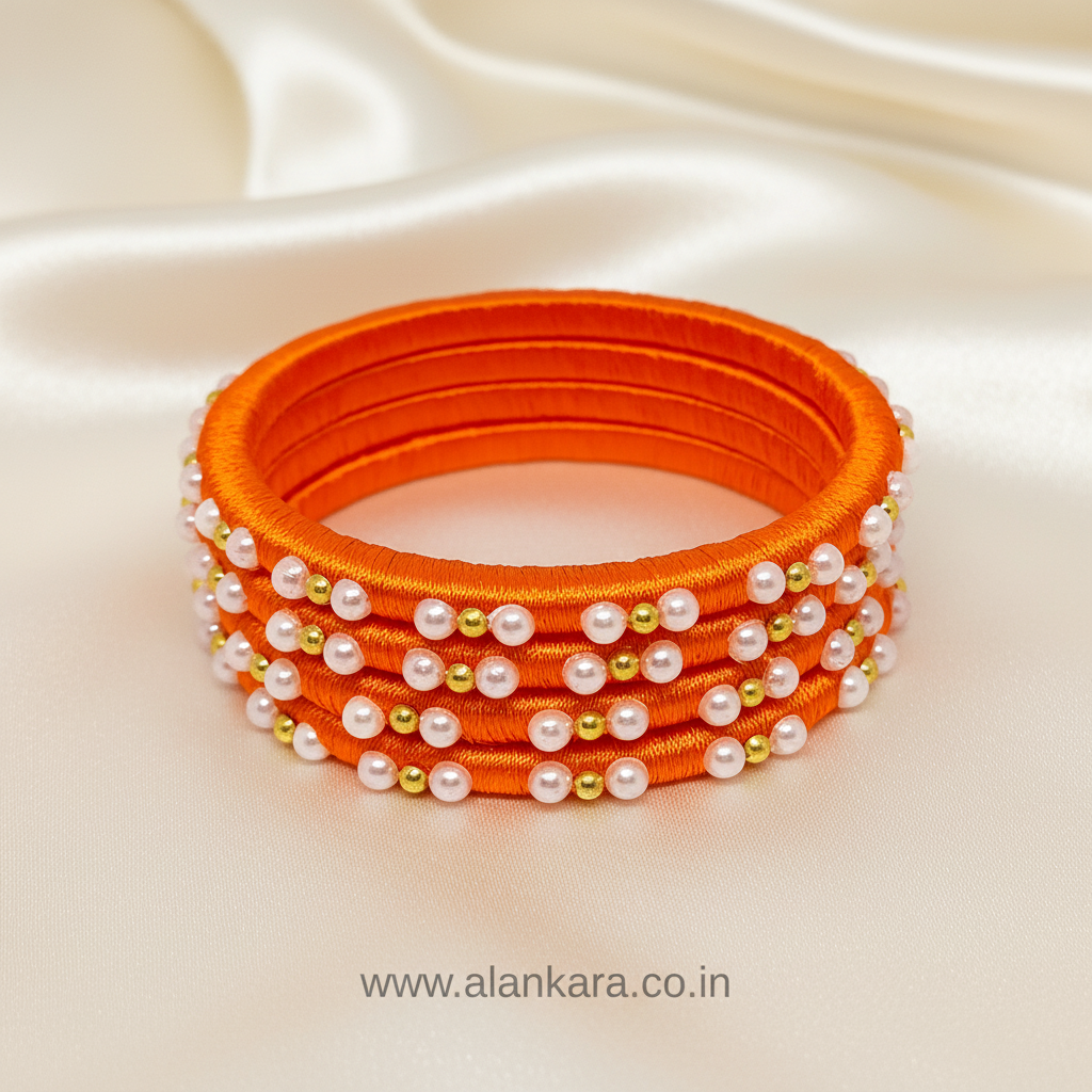 Orange Pearl Silk Thread Bangles featuring vibrant orange silk and decorated with white pearls and golden beads.