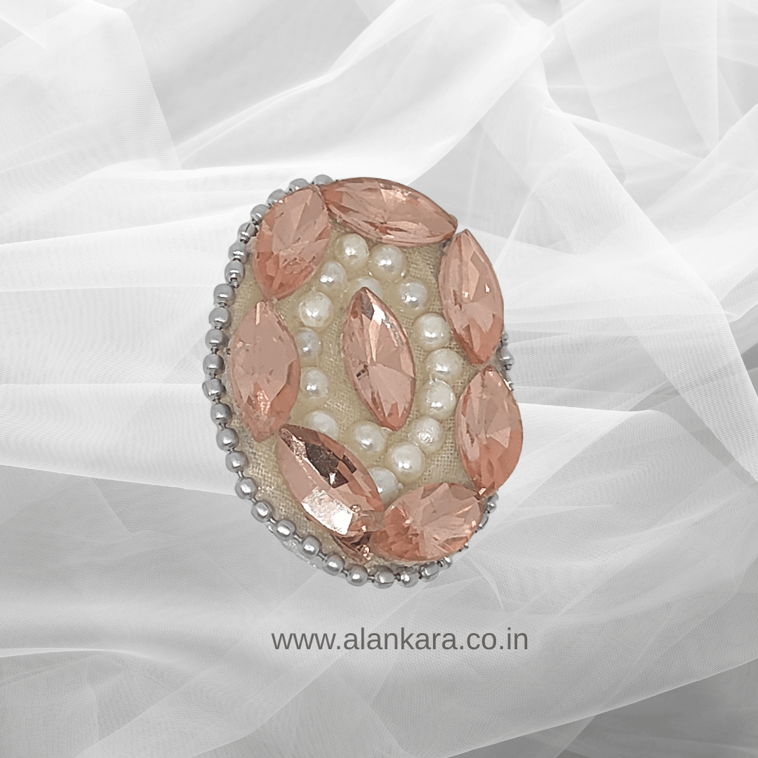 Peach Crystal Pearl Saree Pin adorned with crystals and pearls, set against soft fabric for an elegant ethnic look.