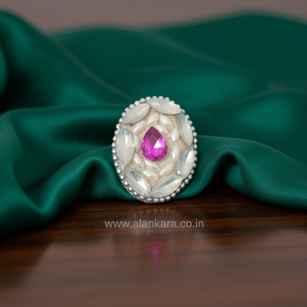 Royal Pink Crystal and Pearl Saree Pin on green fabric, showcasing sparkling crystals and elegant pearl detailing.