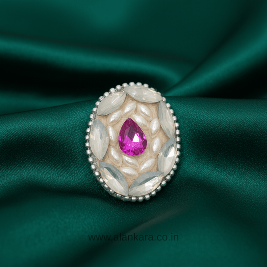 Royal Pink Crystal and Pearl Saree Pin featuring pink crystal and pearl detailing on green fabric.