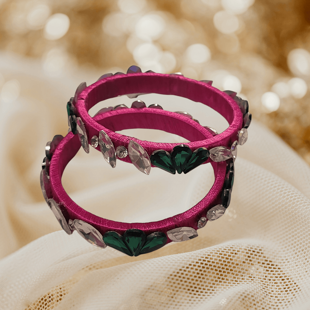 Rani pink floral crystal silk thread bangles adorned with green and white crystals.