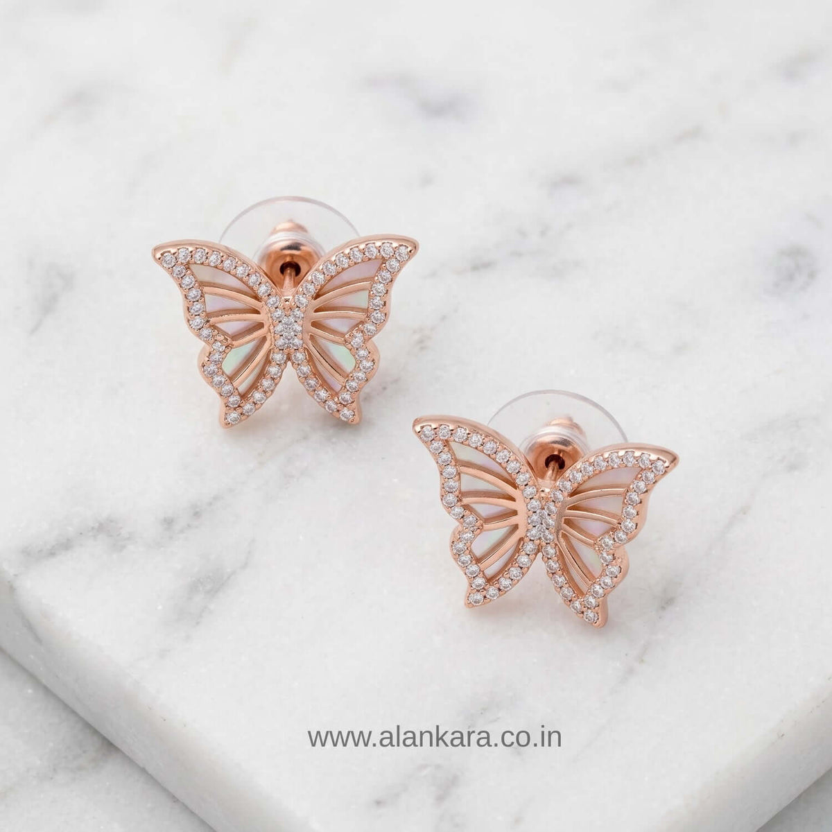Rosegold Butterfly Stud earrings featuring cubic zirconia stones on a marble surface.