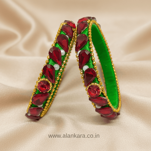 Green & Red Silk Thread Kada Bangles featuring red crystals and green silk thread on a satin background.