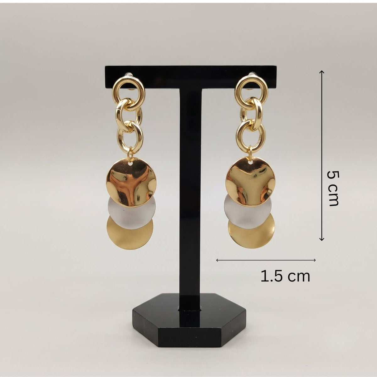 Gold Rosegold Silver Dangler earrings displayed on a stand, showcasing their unique combination of colors and design.