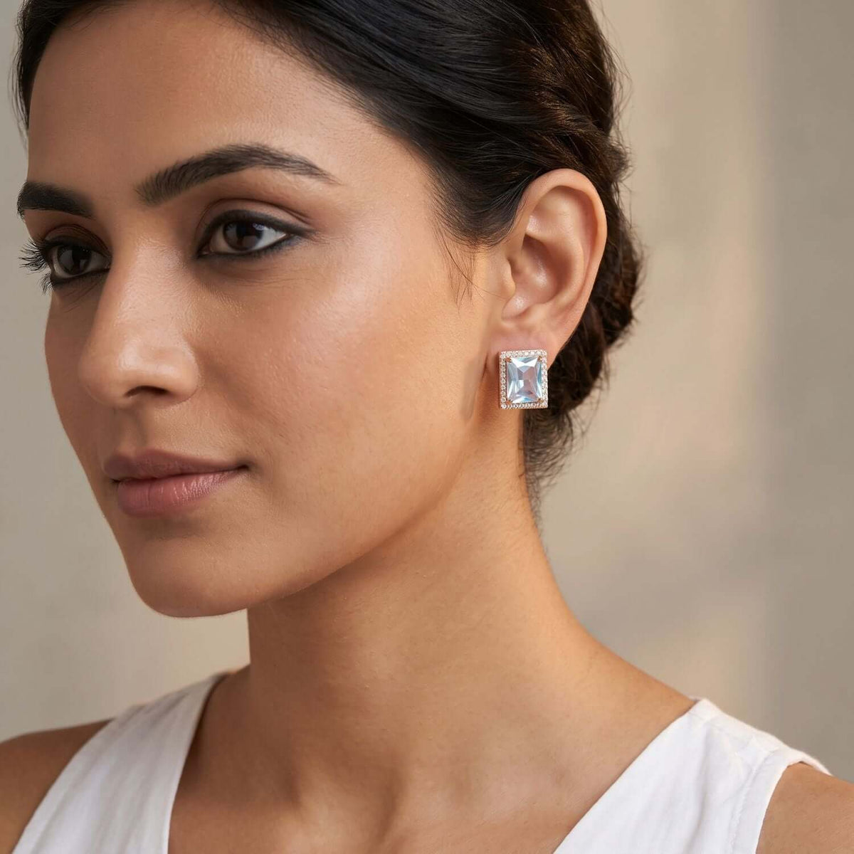 Close-up of a model wearing a White Crystal Stud earring made with Cubic Zirconia, styled elegantly with a white top.