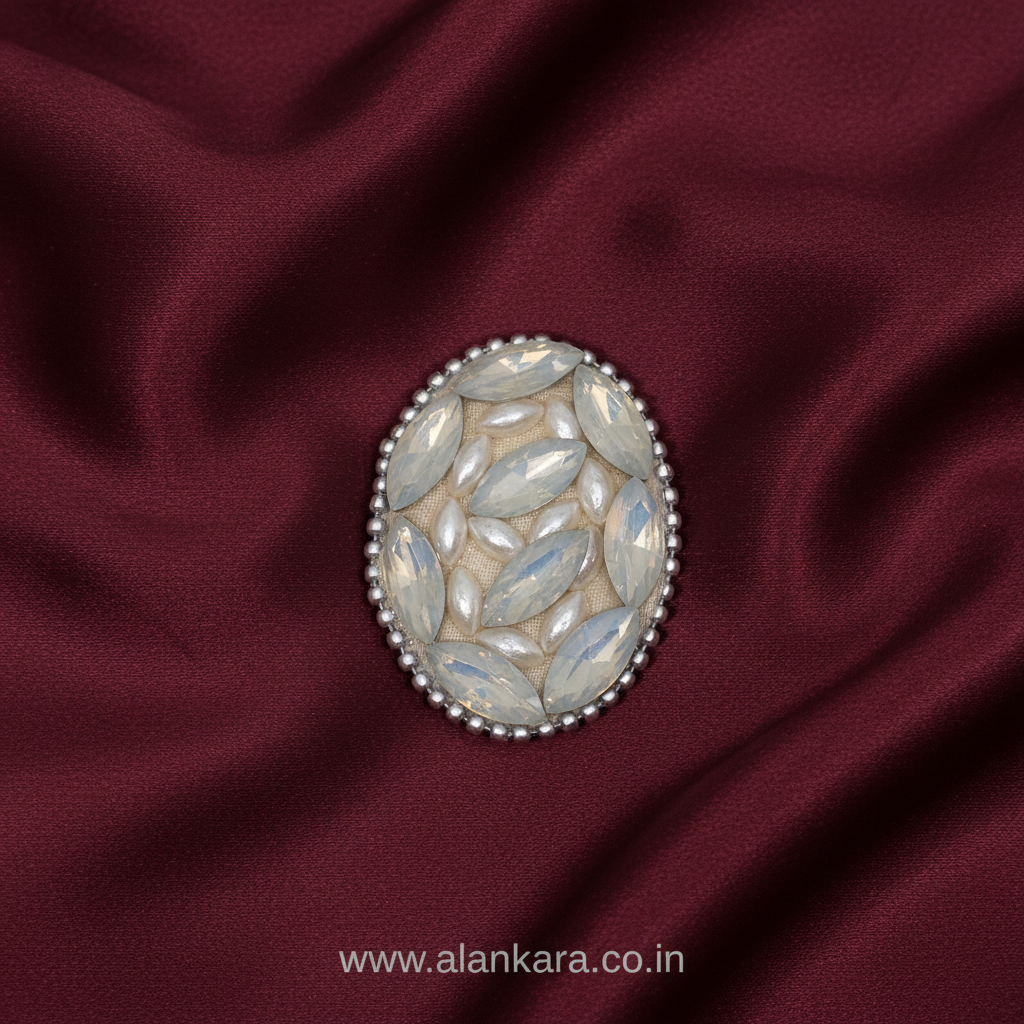 White Pearl Crystal Saree Pin resting on rich burgundy fabric, showcasing elegant design and intricate details.