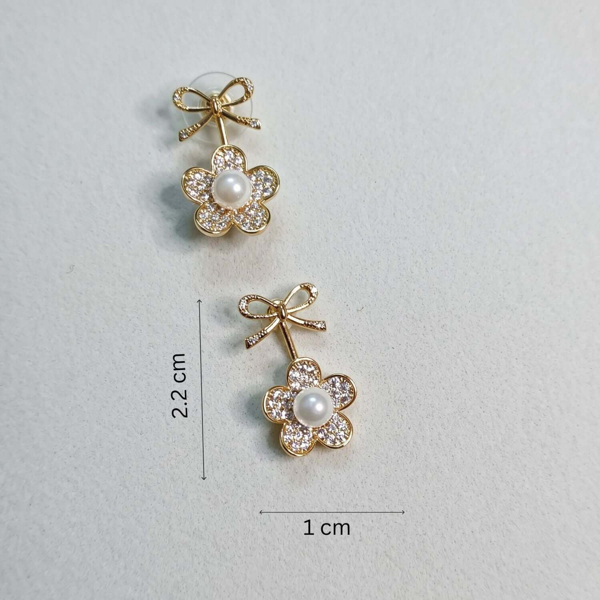 White Pearl Bow Stud earrings with gold plating and cubic zirconia, dimensions 2.2 cm by 1 cm.