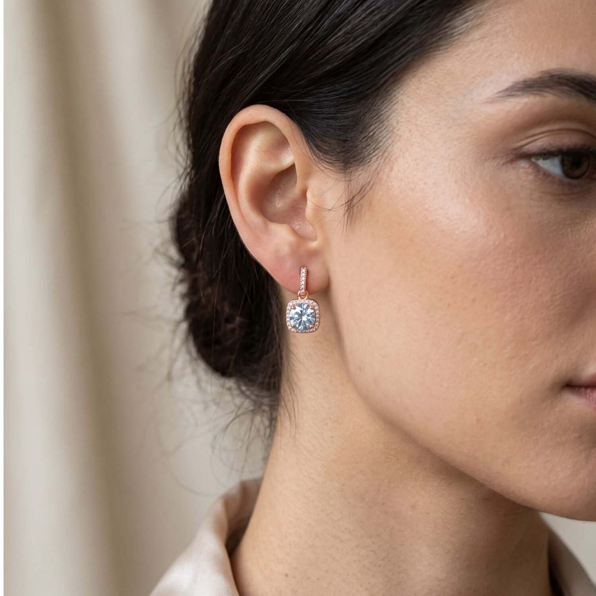 Close-up of a woman wearing White Rhinestone stud earring, styled with elegant attire, showcasing its sparkle.