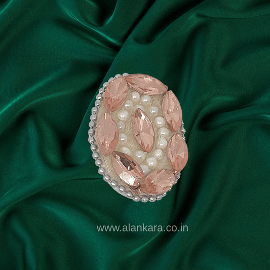 Peach Crystal Pearl Saree Pin featuring sparkling crystals and pearls on a green silk background.