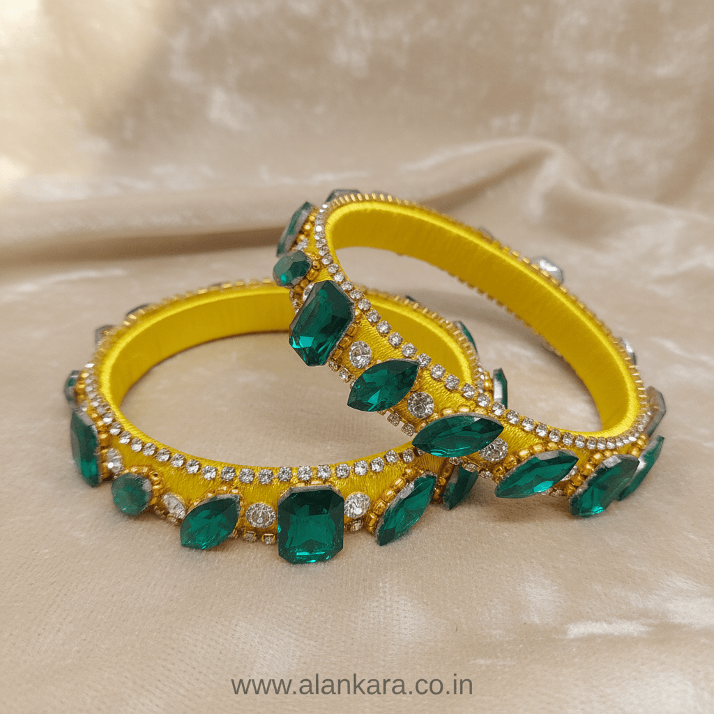 Yellow & Green Noori Silk Thread Kada Bangles adorned with emerald stones and crystals on a golden background.